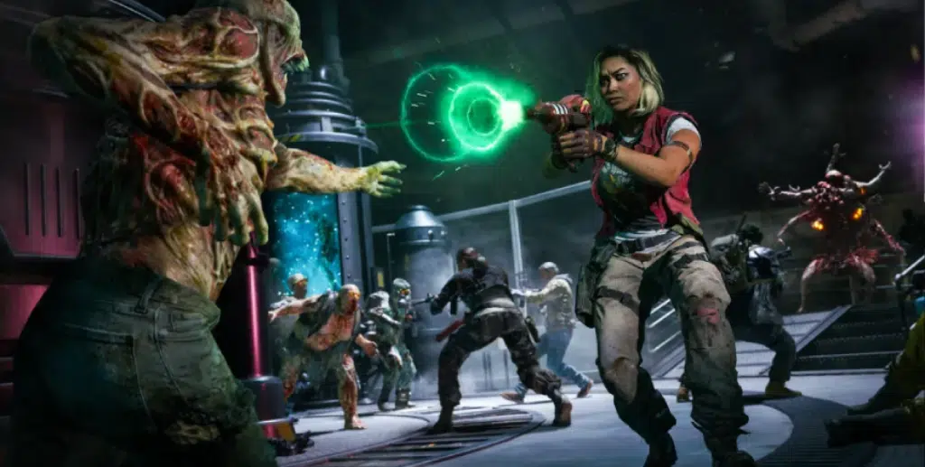 A heavily armed female character, wielding the ray gun, is engaged in combat against mutated zombies. The chaotic scene is set inside a dark, industrial facility, with more zombies approaching in the background. The action-packed atmosphere and monstrous enemies highlight the survival horror elements of zombies mode, a key part of the Call of Duty universe.